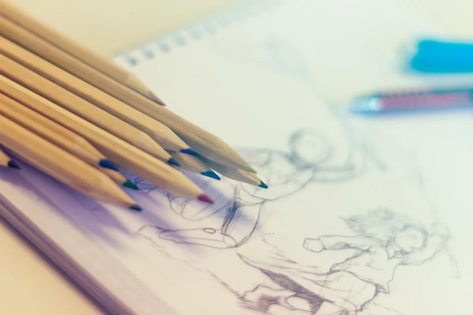Colored pencils resting on a sketchbook page