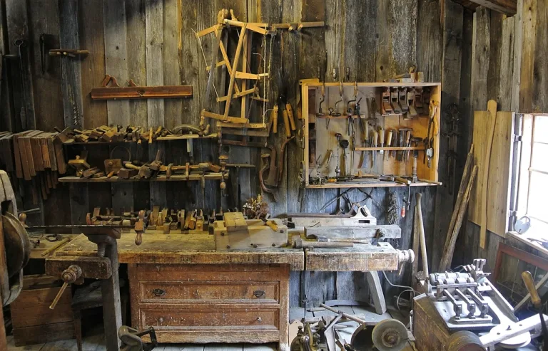 A home woodworking shop with a workbench and hand tools hanging on the wall