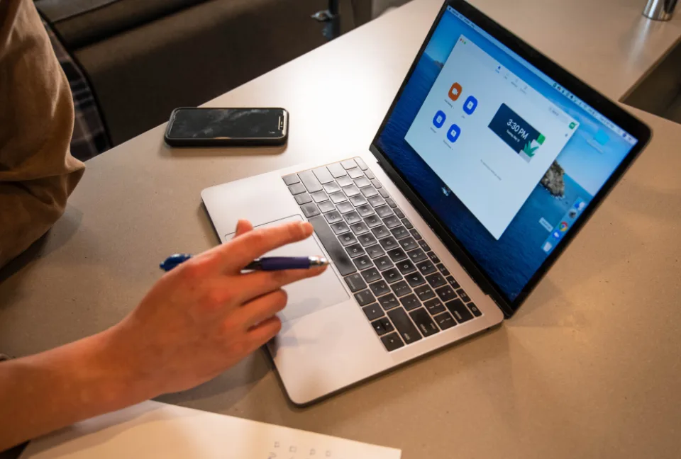 Hands at a laptop on a home desk, ready for an online video lesson