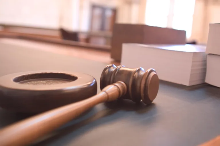 A wooden judge's gavel resting on a courtroom desk